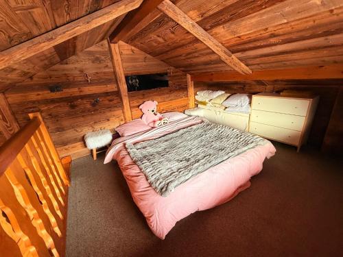 een slaapkamer met een groot bed in een blokhut bij Chalet Cosy Les Gets Vue Montagne in Les Gets