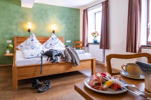 a bedroom with a bed and a table with a plate of food at Landhaus Wern's Mühle in Ottweiler