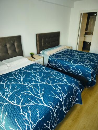two beds sitting next to each other in a room at Depa Bonito en Condominio ! in Tacna