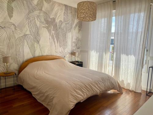 une chambre avec un lit avec un dessin sur le mur dans l'établissement Bel appartement centre-ville, à Lorient