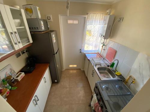 a small kitchen with a sink and a refrigerator at Habitación cama 2 P, en zona residencial cerca Mall plaza, UCM, Casino Talca in Talca