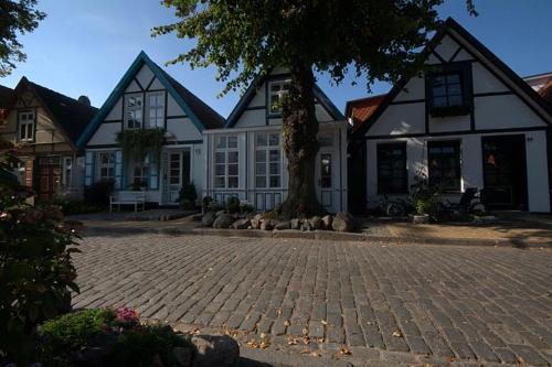a large house with a tree in front of it at Vogel Hotel & Appartements in Warnemünde