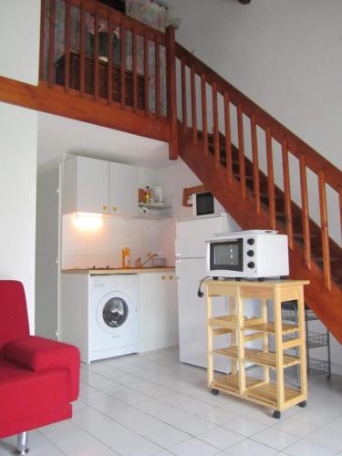une cuisine avec un escalier et un four micro-ondes sur une table dans l'établissement Villa de vacances à la Marina avec WIFI proche plage, à Saint Cyprien Plage