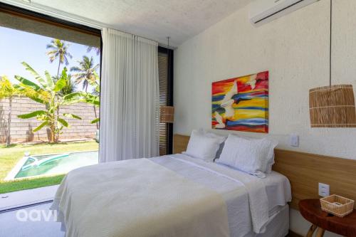 ein Schlafzimmer mit einem Bett und einem großen Fenster in der Unterkunft Casa com Piscina na Praia de Tatuamunha by Qavi in Tatuamunha
