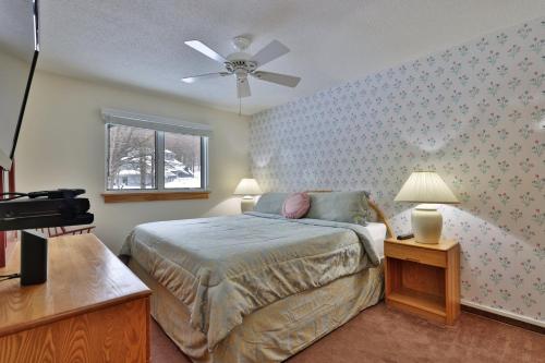 a bedroom with a bed and a ceiling fan at Woods Resort and Spa - Cozy 2-Bedroom Condo Minutes to Ski Resort - Spa, Pool, Hot Tub, Tennis, Fireplace in Killington
