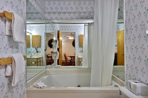 a bathroom with a tub and a mirror at Woods Resort and Spa - Cozy 2-Bedroom Condo Minutes to Ski Resort - Spa, Pool, Hot Tub, Tennis, Fireplace in Killington