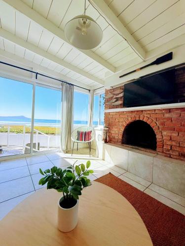 a living room with a brick fireplace and a plant at CASA PLAYA - Beachfront Paradise sandy beach in Ensenada