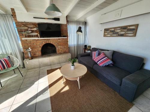 a living room with a blue couch and a fireplace at CASA PLAYA - Beachfront Paradise sandy beach in Ensenada