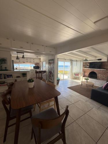 a dining room and living room with a table and a couch at CASA PLAYA - Beachfront Paradise sandy beach in Ensenada