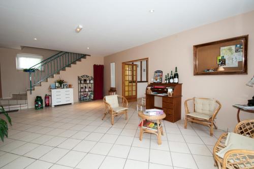 - un salon avec des chaises, une table et des escaliers dans l'établissement La Janenquelle, à Sarry