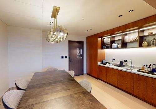 a dining room with a wooden table and a kitchen at Nobu Hotel Atlanta in Atlanta