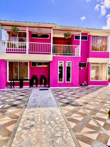 a pink building with chairs in front of it at Posada Seven Colours Ocean in Providencia