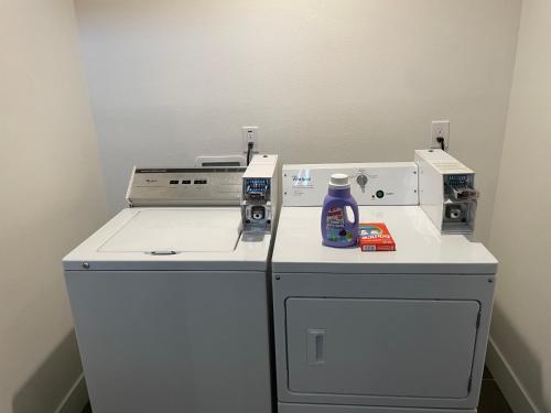 a washing machine with a bottle of detergent on top of it at The Blue Hostel - Private Room With Private Bath - USC - DTLA - BMO Stadium - LA OLYMPIC - STAPLES CENTER in Los Angeles