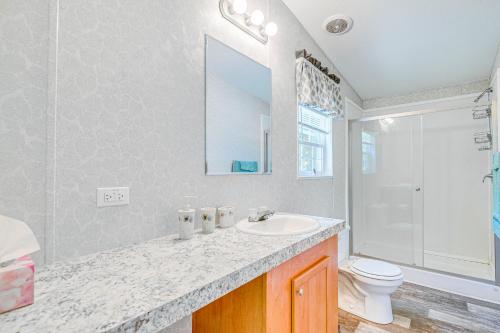 a bathroom with a sink and a toilet and a mirror at 7 Mi to Crystal River Home with Yard and Fire Pit! in Crystal River