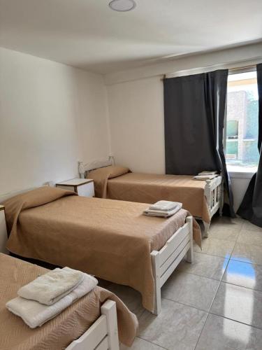a room with three beds and a window at San rafael del diamante apartamentos in San Rafael