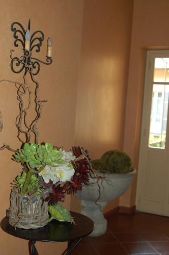 a vase of flowers on a table next to a wall at Albergo Residence Perosi in Tortona
