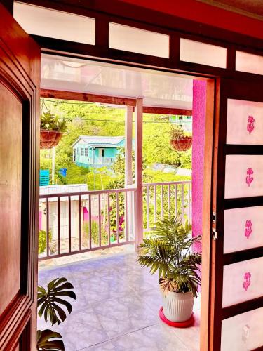 an open door to a balcony with a house at Posada Seven Colours Ocean in Providencia