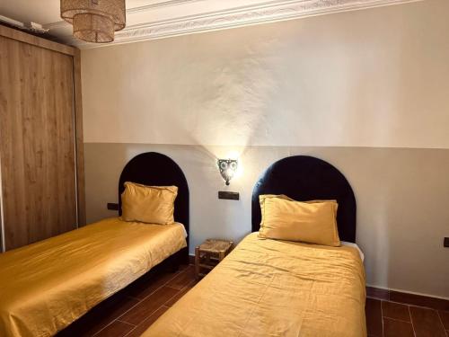two beds sitting next to each other in a room at Charming app 3 min Sania Ramel AIRPORT Tetuan in Tetouan