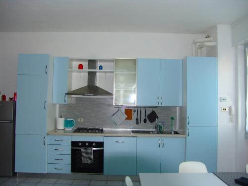 a kitchen with blue cabinets and a stove at Benny's Apartment Near Lake Como in Bulciago
