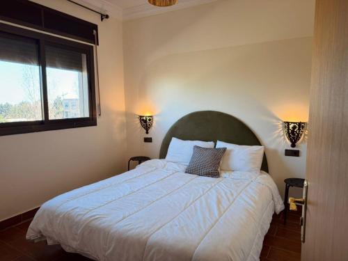 得土安Charming app 3 min Sania Ramel AIRPORT Tetuan的卧室里有一张白色的大床，上面有两个枕头