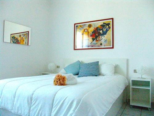 a bedroom with a white bed with a picture on the wall at Benny's Apartment Near Lake Como in Bulciago