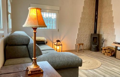 a living room with a couch and a lamp on a table at Paraje Sanchazurra in Vallejera de Riofrío