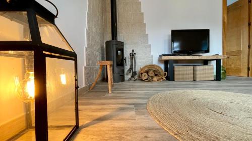 a living room with a fireplace and a tv at Paraje Sanchazurra in Vallejera de Riofrío