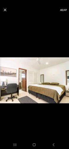 a bedroom with a bed and a desk and a chair at Marinares apartamento in Cartagena de Indias