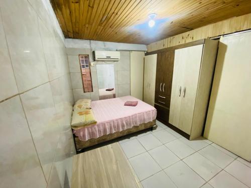a small room with a small pink bed in it at Casa Completa para Hospedagem in Rosário do Sul
