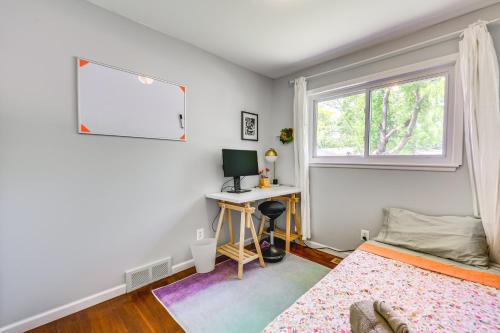 a bedroom with a bed and a desk and a window at Charming Ann Arbor Getaway with Deck Near Downtown! in Ann Arbor