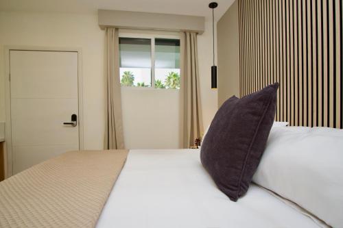 a bedroom with a bed with a pillow on it at Rio Suites in Tijuana