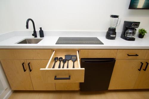 a kitchen with a sink and a drawer with utensils at Rio Suites in Tijuana