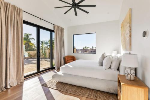 a white bedroom with a bed and a large window at Vintners Village California-Chic Wine Estate in Country Road Estates
