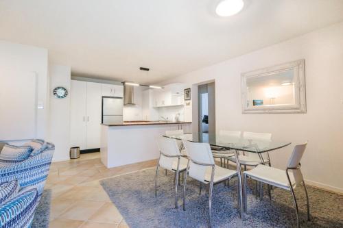 a dining room and kitchen with a table and chairs at Onetangi Beach Apartments in Onetangi