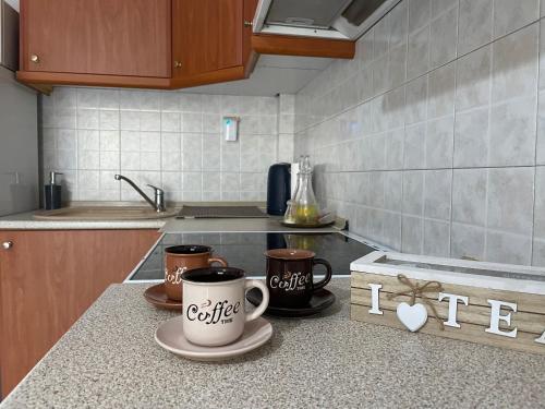 a kitchen with two coffee cups on a counter at Διαμέρισμα με θέα σε πάρκο! in Serres