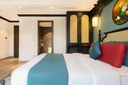 a bedroom with a large bed with colorful pillows at Hanoi Bliss Hotel in Hanoi