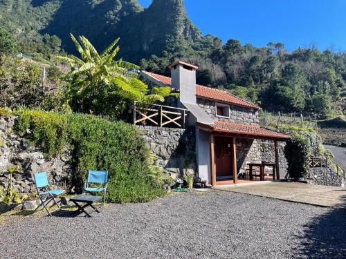a stone house with two chairs in front of it at Zef's Cottage in São Vicente