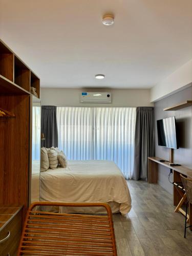 a hotel room with a bed and a television at Moon House San Telmo in Buenos Aires
