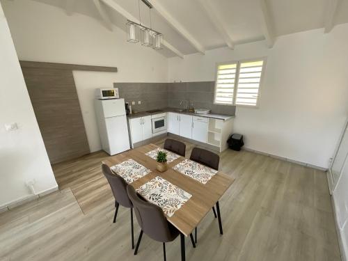 a kitchen and dining room with a table and chairs at Location Les Flamboyants in Sainte-Anne