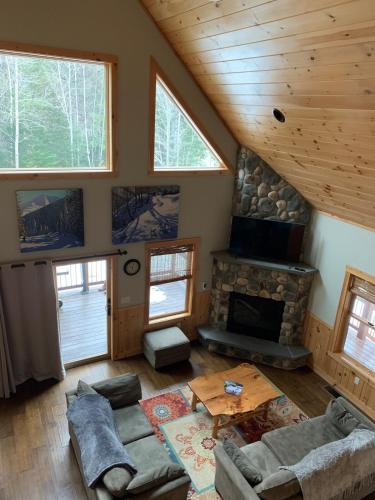 ein Wohnzimmer mit Couch und Kamin in der Unterkunft Ski Chalet btwn SundayRiver & MtAbram in Bethel