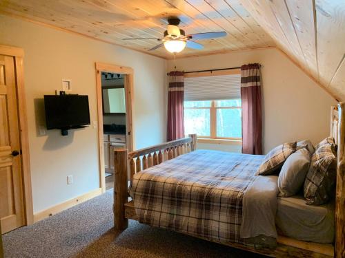 ein Schlafzimmer mit einem Bett und einem Deckenventilator in der Unterkunft Ski Chalet btwn SundayRiver & MtAbram in Bethel
