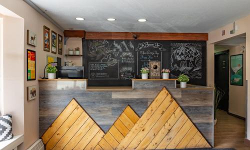 a bar in a restaurant with a chalkboard wall at Samesun Banff Hostel in Banff