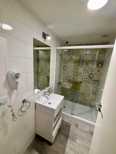 a white bathroom with a sink and a shower at Moon House San Telmo in Buenos Aires