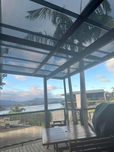 a patio with a table and a view of the water at Coromandel Seaview Motel in Coromandel Town