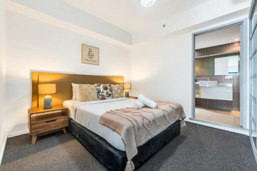 a bedroom with a large bed and a large window at Stunning City Views from Modern 1BR Apartment King in Darwin