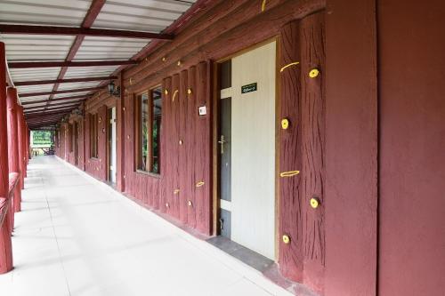 an empty hallway of a building with red walls at Townhouse OAK Gorumara Jungle Resort in Chālsa Mahābāri