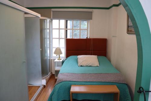 Un dormitorio pequeño con una cama y una ventana. en The 222, en Ciudad de México