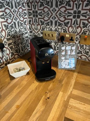 a coffee maker sitting on a wooden floor next to a wall at Warden's Close Apartments in Edinburgh
