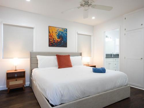 塔斯廷Renovated Retreat 4BR Oasis w Pool and Pool Table的卧室里有一张白色的床，墙上挂着一幅画