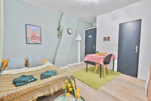 - une chambre avec un lit et une table avec une couverture rose dans l'établissement LE LITTLE ITALY - Parking I Netflix I WIFI - Dolce & Cosy, à Anzin